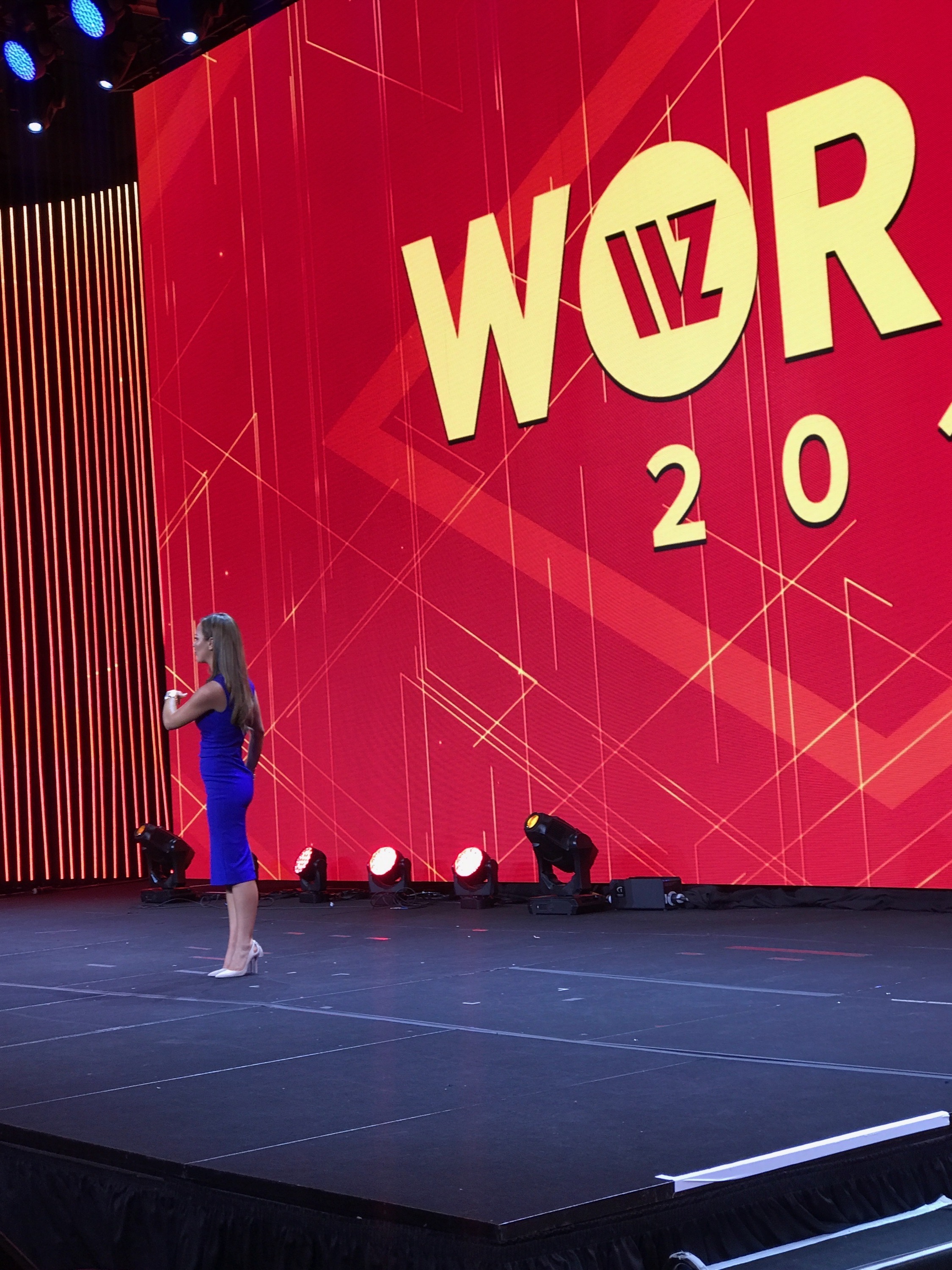 Nicole Lapin delivering a conference keynote on a red stage